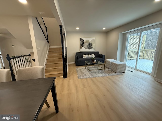 living room featuring recessed lighting, wood finished floors, visible vents, baseboards, and stairway