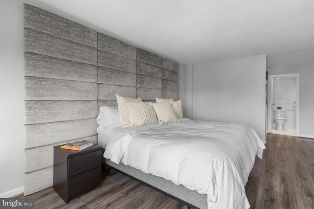 bedroom with baseboards, wood finished floors, and ensuite bathroom