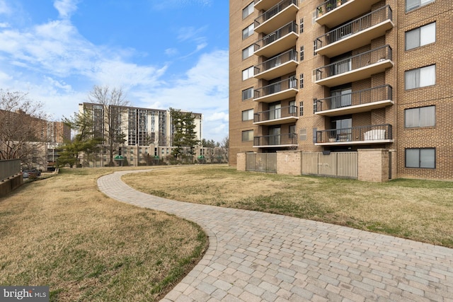 view of property's community with fence and a lawn