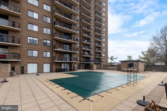 pool featuring fence and a patio