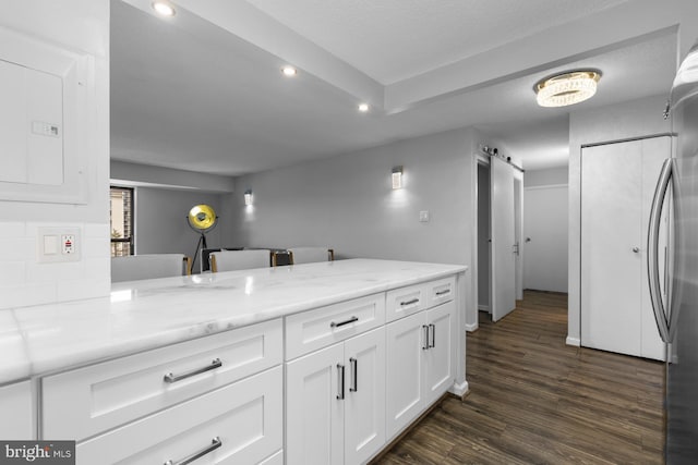 kitchen with a barn door, recessed lighting, white cabinetry, electric panel, and dark wood finished floors