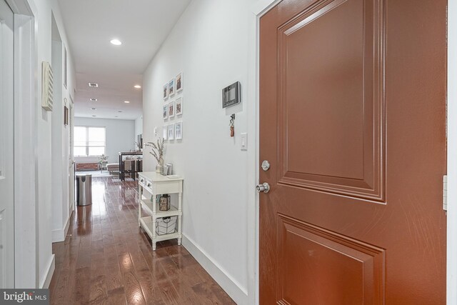 hallway featuring baseboards, dark wood-type flooring, and recessed lighting