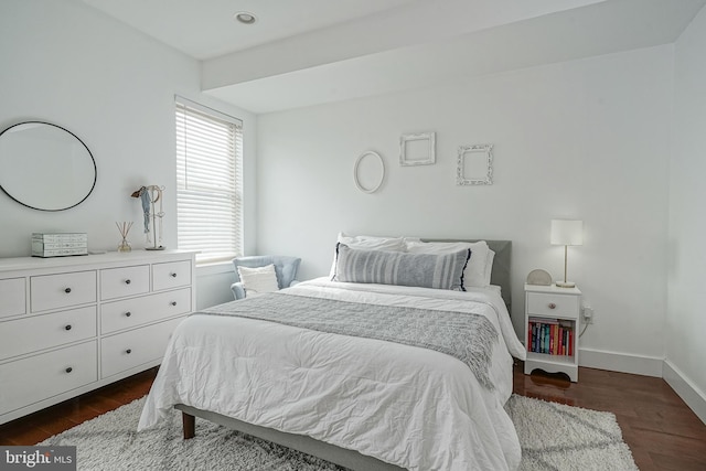 bedroom with dark wood-type flooring and baseboards