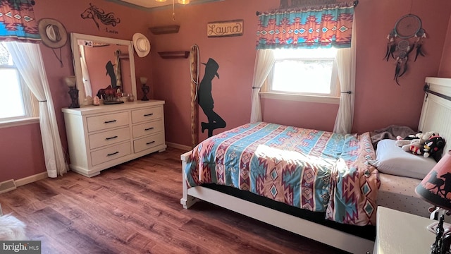 bedroom featuring light wood finished floors and baseboards