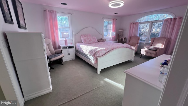 bedroom with visible vents and light colored carpet