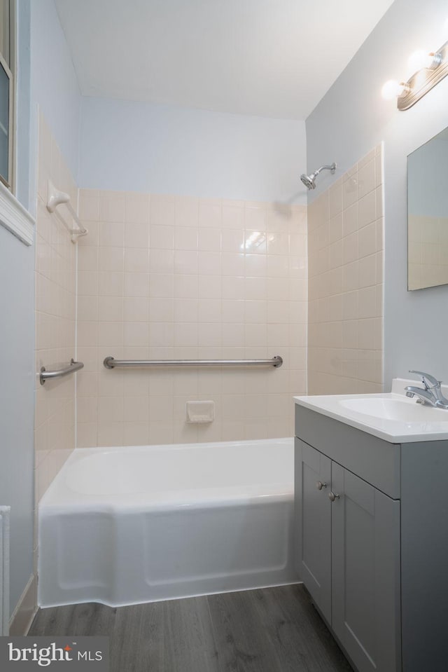 bathroom featuring radiator heating unit, vanity, shower / tub combination, and wood finished floors