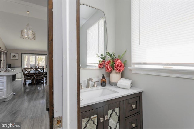 bathroom featuring a notable chandelier, vanity, and wood finished floors