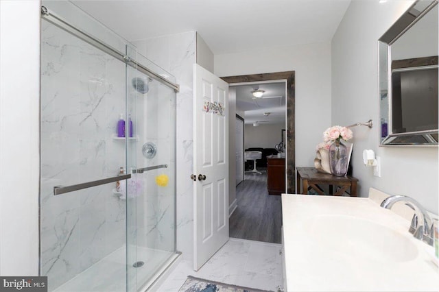 bathroom with a marble finish shower, marble finish floor, ensuite bath, and vanity
