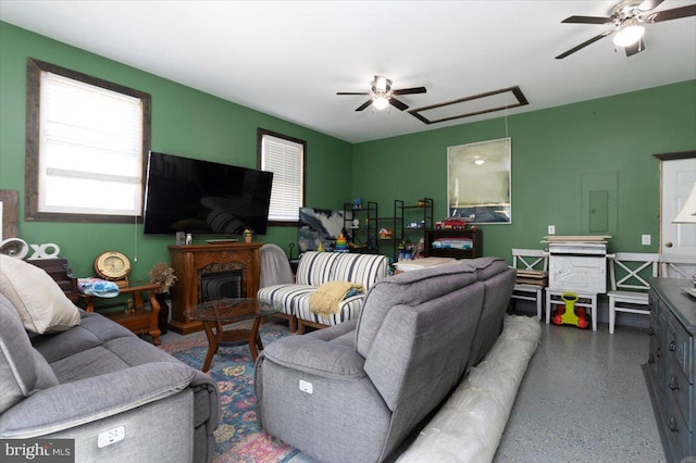 living room with speckled floor, attic access, and ceiling fan