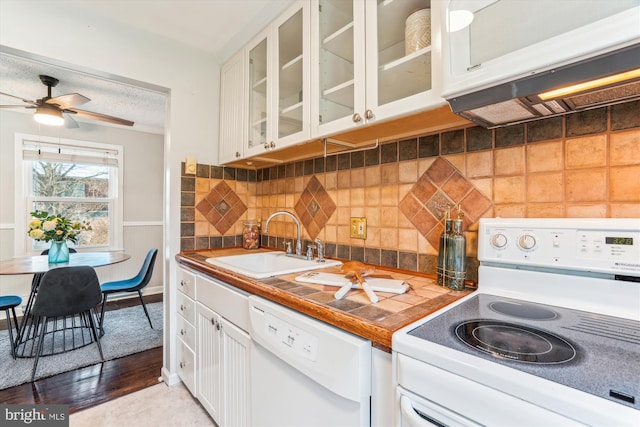 kitchen featuring white appliances, decorative backsplash, glass insert cabinets, white cabinetry, and a sink