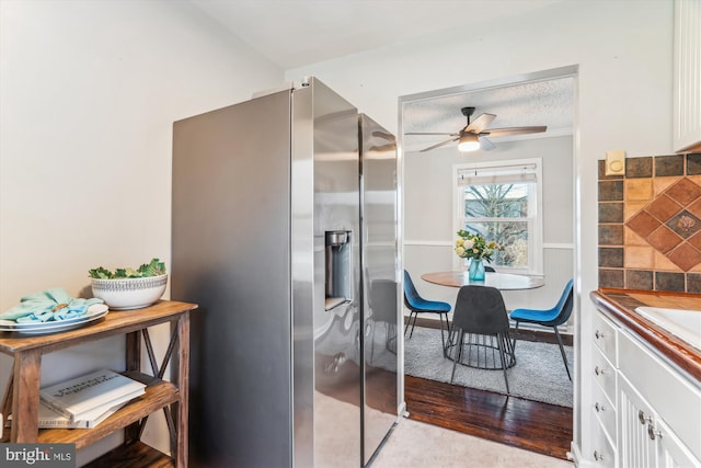 interior space with wainscoting, ceiling fan, a textured ceiling, and wood finished floors