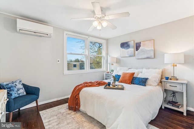 bedroom with an AC wall unit, wood finished floors, a ceiling fan, and baseboards