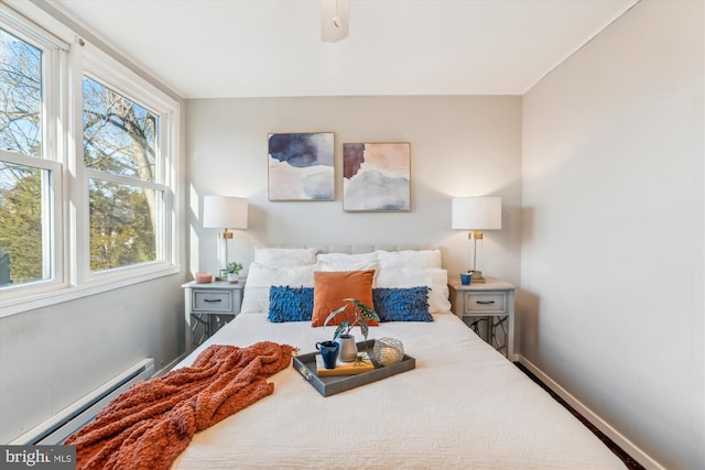 bedroom with a baseboard radiator, a ceiling fan, and baseboards