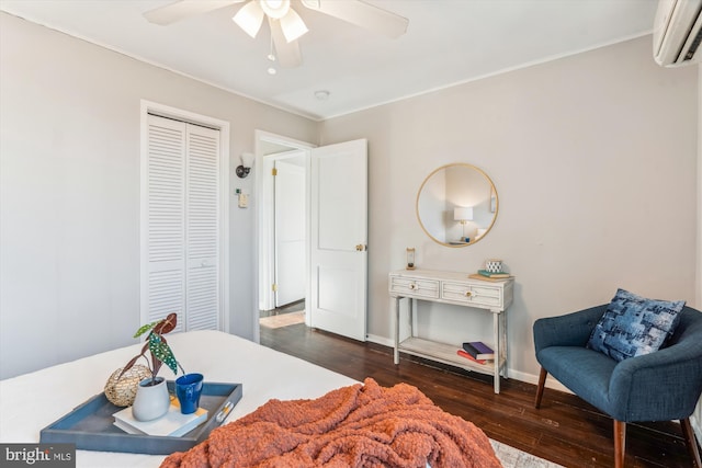 bedroom with baseboards, ceiling fan, wood finished floors, a closet, and a wall mounted AC