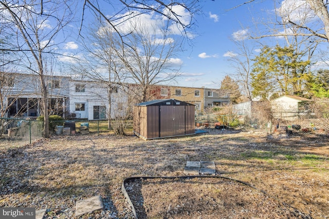 view of yard with a fenced backyard, a storage unit, and an outdoor structure