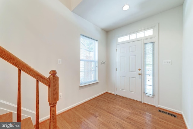 entryway with light wood-style flooring, stairway, visible vents, and baseboards