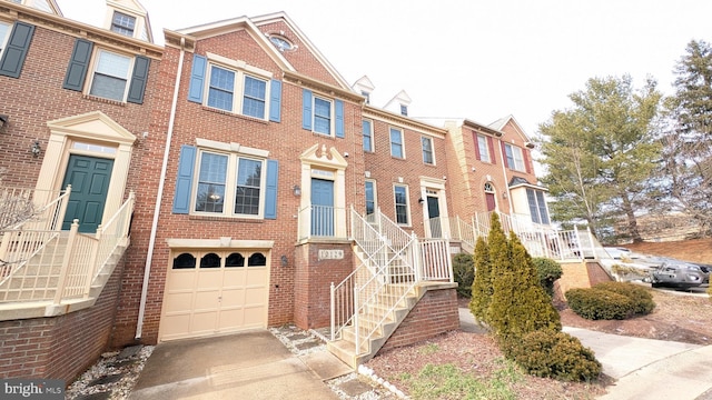 multi unit property with concrete driveway, a garage, and brick siding