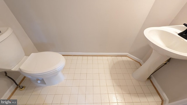 half bath featuring toilet and tile patterned flooring