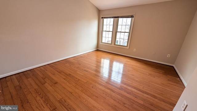 unfurnished room featuring baseboards and wood finished floors