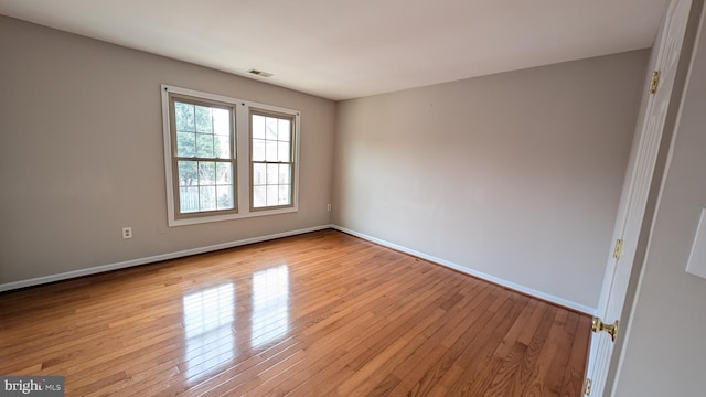 unfurnished room with hardwood / wood-style flooring and baseboards