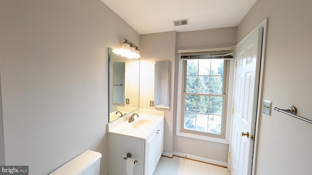 bathroom with vanity, toilet, visible vents, and a wealth of natural light