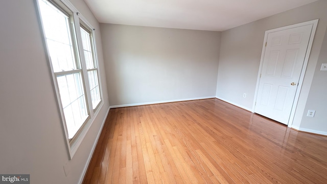 empty room with baseboards and light wood finished floors