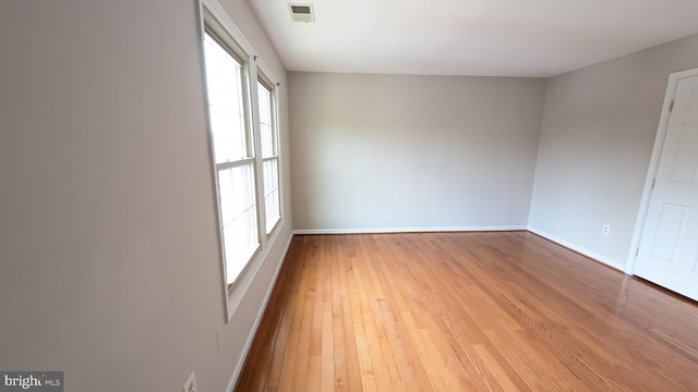 empty room with visible vents, baseboards, and light wood-style floors