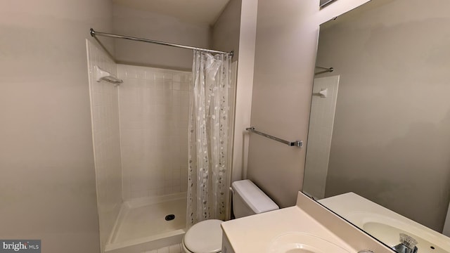 bathroom featuring vanity, toilet, and a tile shower