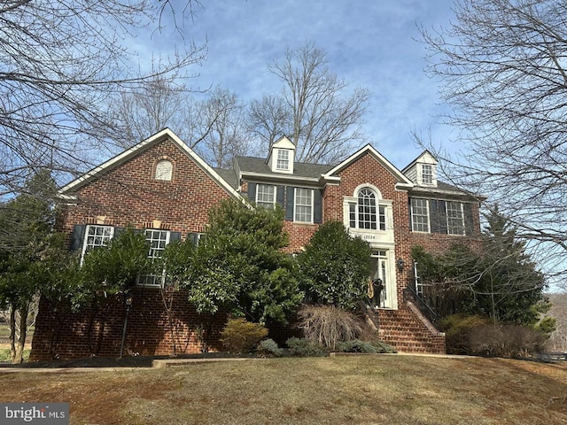 view of front of property featuring a front lawn and brick siding