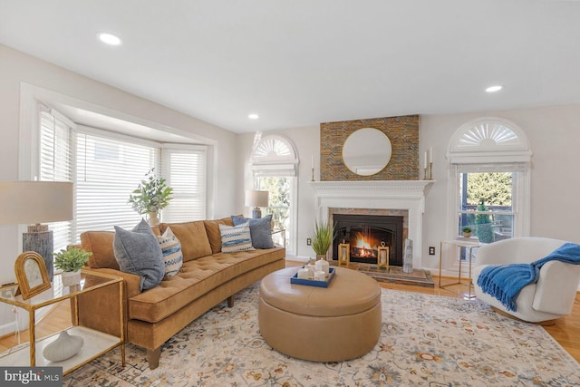 living room with a lit fireplace, baseboards, a wealth of natural light, and recessed lighting