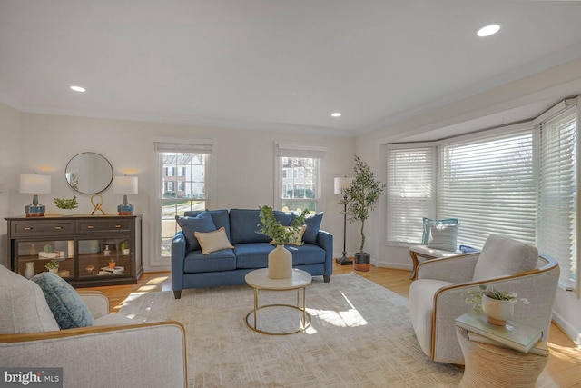 living area featuring recessed lighting, crown molding, baseboards, and wood finished floors