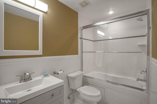 full bath with enclosed tub / shower combo, toilet, a wainscoted wall, vanity, and visible vents