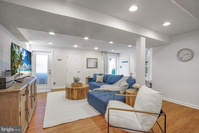 living area with light wood-style flooring and recessed lighting