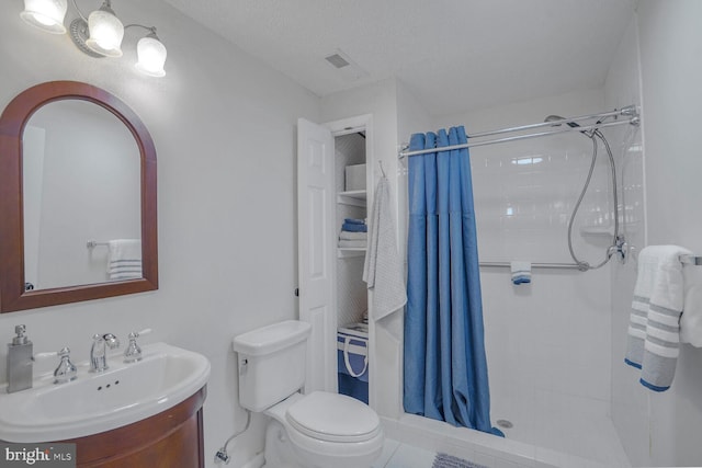 bathroom featuring a stall shower, visible vents, vanity, and toilet