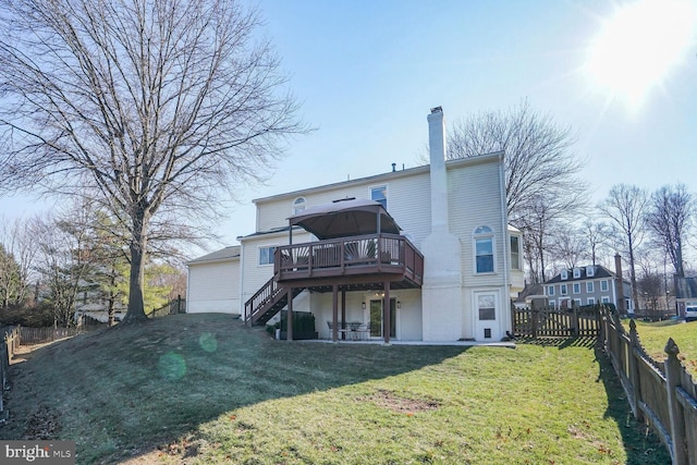 back of property featuring a fenced backyard, a yard, stairway, a wooden deck, and a chimney