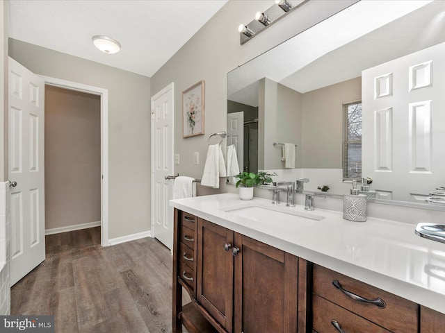 full bath with vanity, baseboards, and wood finished floors