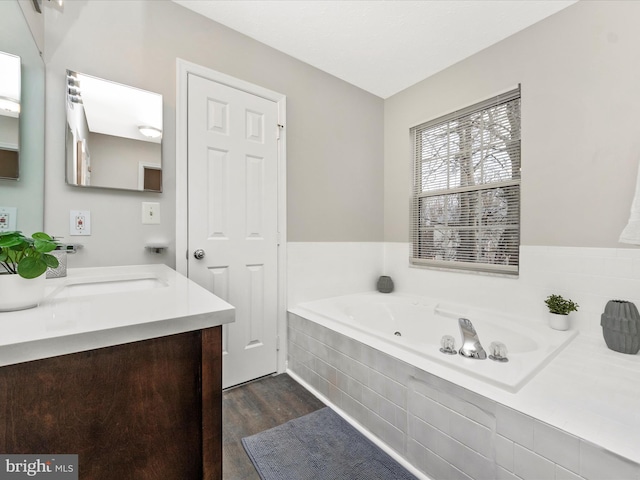 bathroom with vanity, a whirlpool tub, and wood finished floors