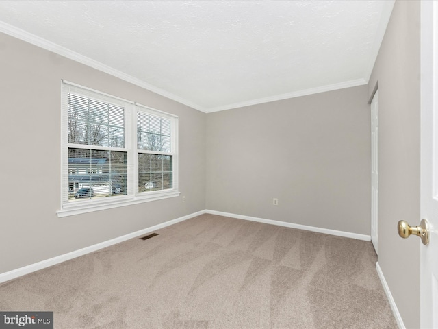 empty room with visible vents, baseboards, a textured ceiling, crown molding, and carpet flooring