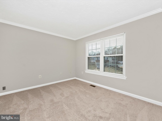 unfurnished room with baseboards, carpet, and crown molding