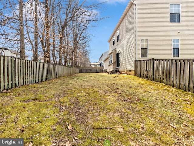 view of yard with entry steps and a fenced backyard