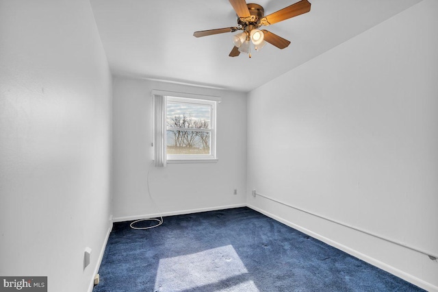 carpeted spare room featuring baseboards and a ceiling fan