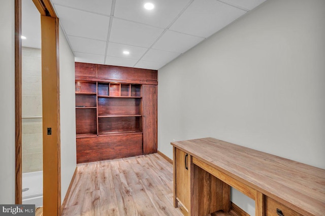 unfurnished office featuring a paneled ceiling and light wood-style flooring