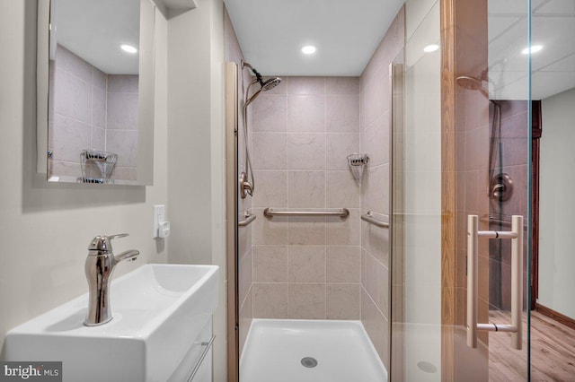 full bathroom with recessed lighting, a shower stall, vanity, and wood finished floors