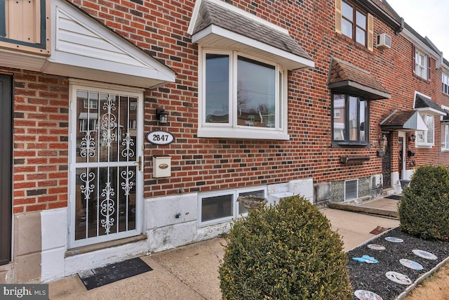 entrance to property featuring brick siding