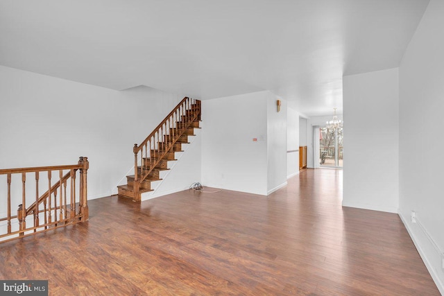 interior space with a chandelier, baseboards, and wood finished floors