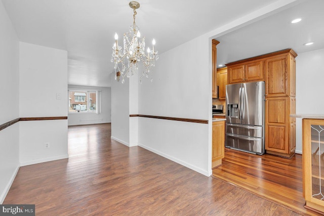 unfurnished dining area with recessed lighting, dark wood-style flooring, baseboards, and an inviting chandelier