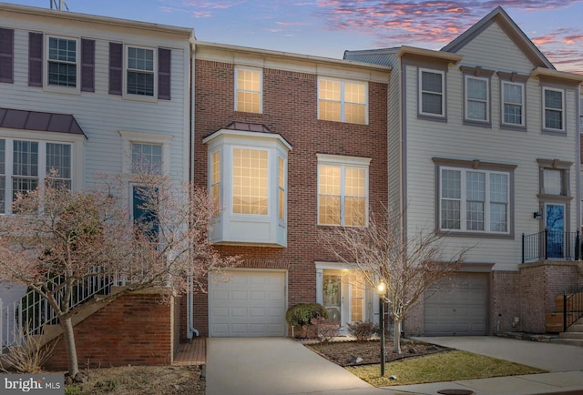 townhome / multi-family property with brick siding and driveway