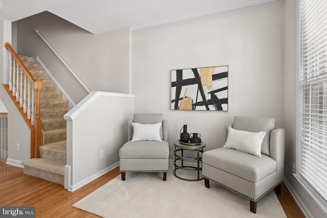 sitting room with stairs, wood finished floors, and baseboards