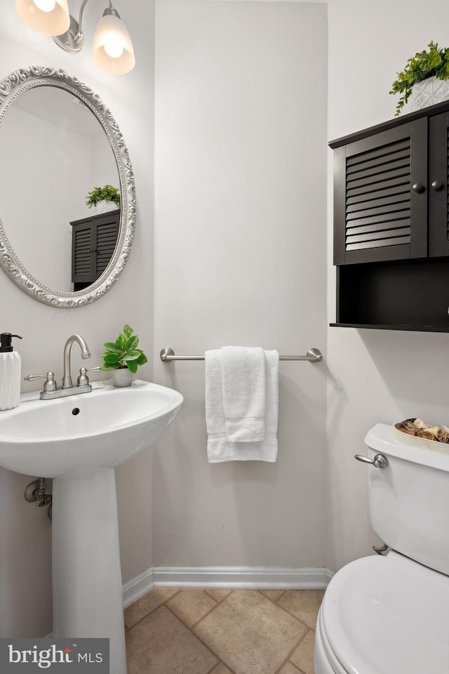 bathroom with toilet and baseboards