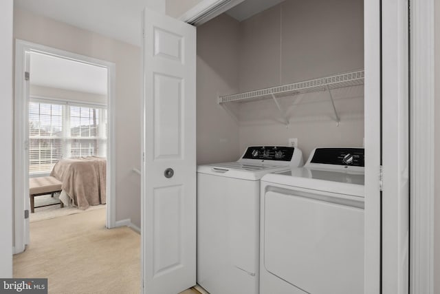 washroom with baseboards, light carpet, independent washer and dryer, and laundry area